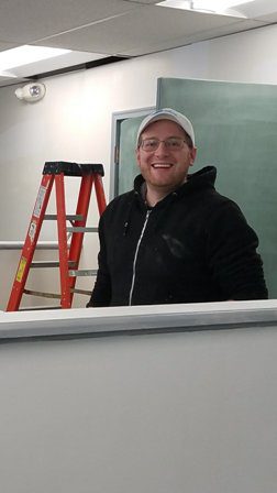 A man standing in front of a desk in an office.