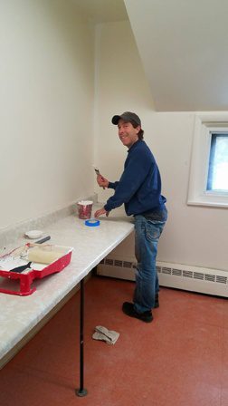 A man working on a table in an empty room.