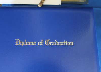 A blue book with the words diploma of graduation on it.