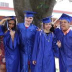 A group of people in graduation gowns posing for a photo.