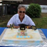 A woman sitting in front of a cake.