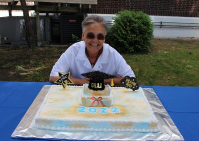 A woman sitting in front of a cake.