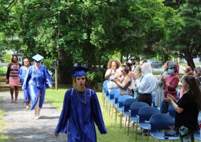 A group of people in graduation gowns walking down a path.