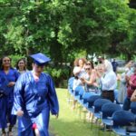 A group of people in graduation gowns walking down a path.