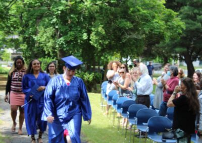 A group of people in graduation gowns walking down a path.