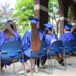 A group of people sitting in chairs at a graduation ceremony.