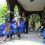 A group of people sitting on chairs at a graduation ceremony.