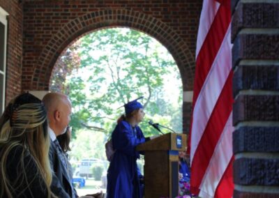 A group of people sitting at a podium in front of an american flag.