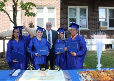 A group of people posing in front of a cake.