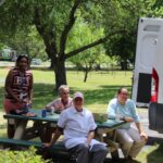 A group of people sitting on a picnic bench.