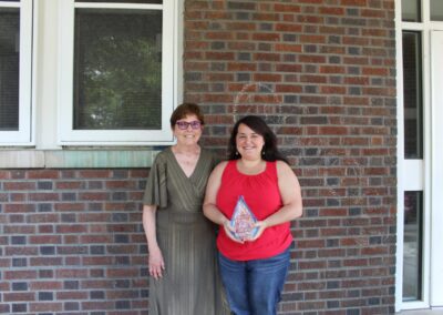 Two women standing in front of a brick building.