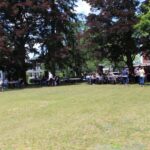 A group of people standing in a grassy area.