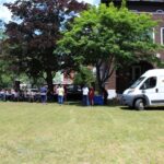 A white van parked in a grassy area.