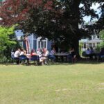 A group of people sitting in a grassy area.