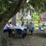 A group of people sitting under a tree.
