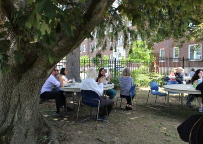 A group of people sitting under a tree.