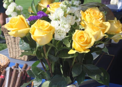 A bunch of yellow roses in a vase on a table.