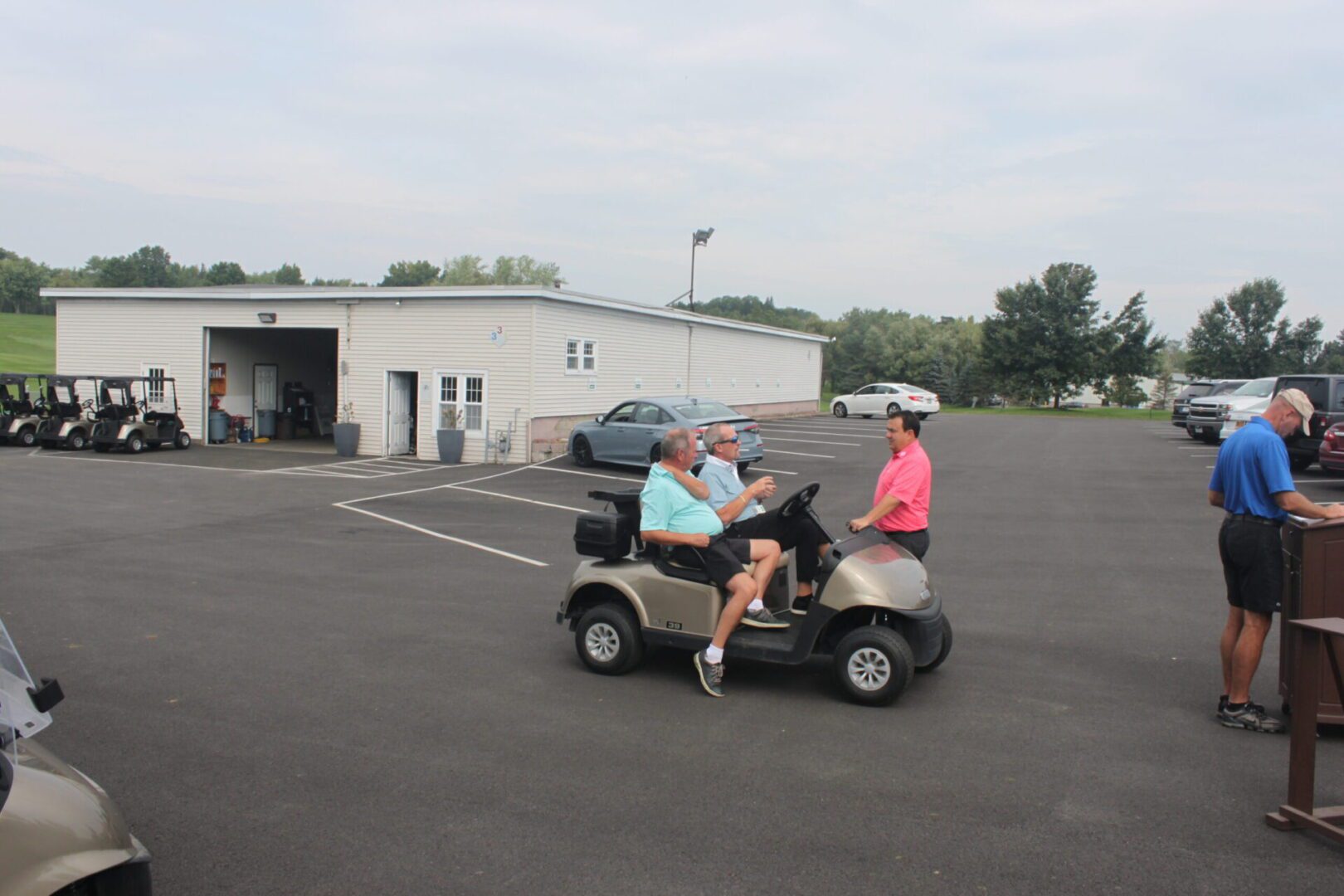 A group of people riding golf carts in a parking lot.