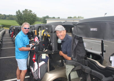 Two golf carts in a parking lot.