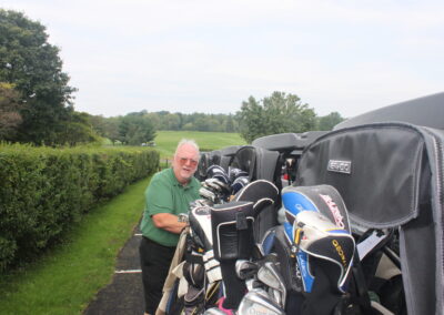 A man standing next to a golf cart.