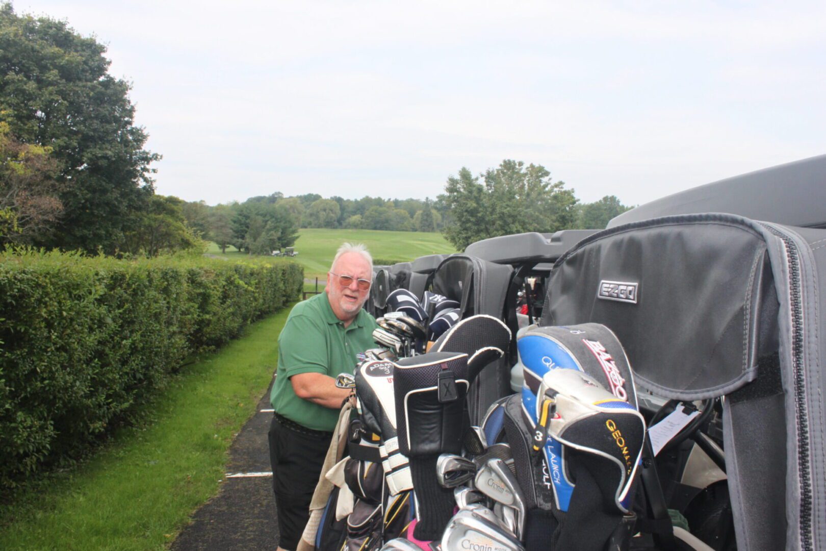 A man standing next to a golf cart.