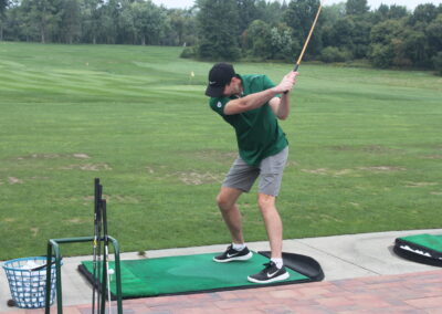 A man is hitting a golf ball on a green.