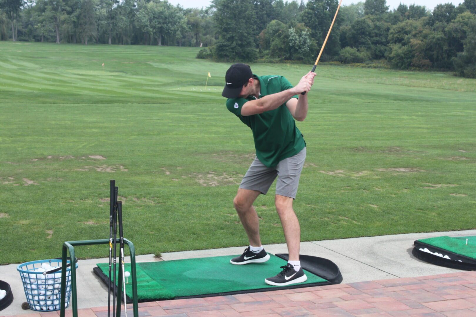 A man is hitting a golf ball on a green.