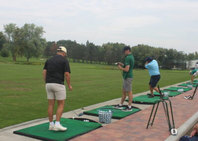 A group of people on a golf tee.