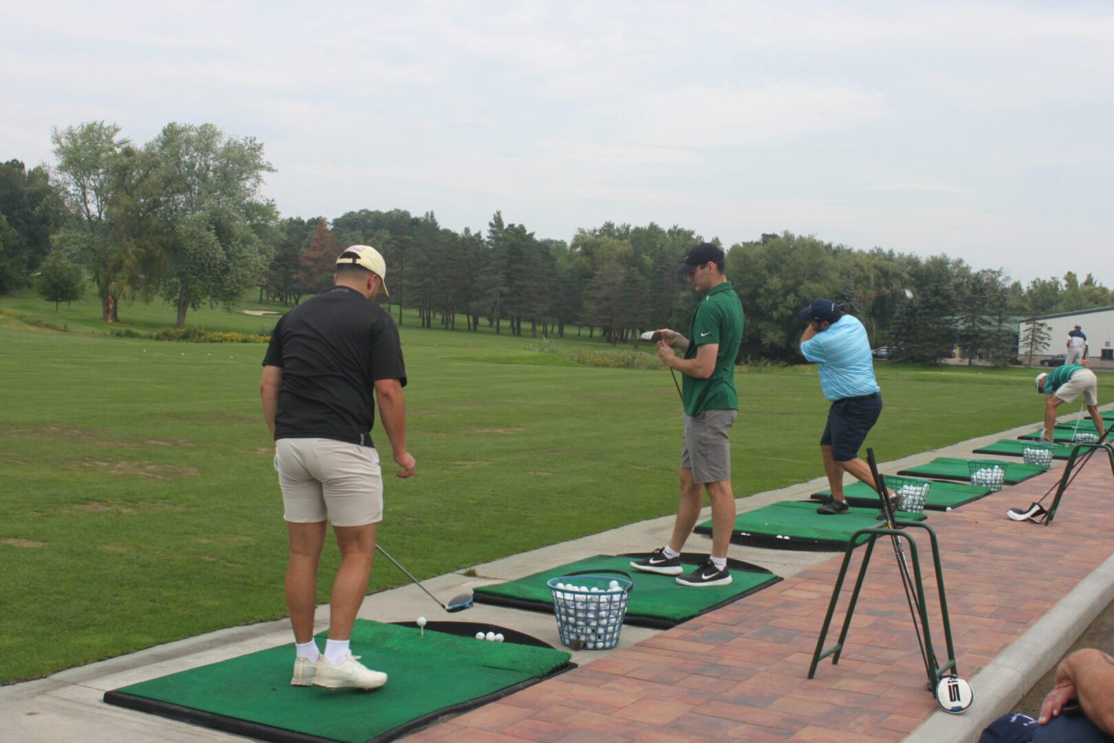 A group of people on a golf tee.