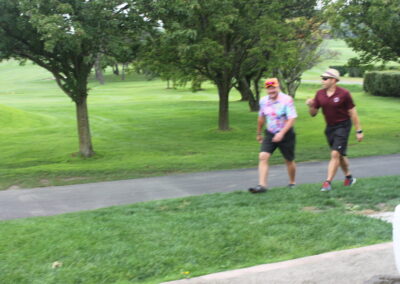 Two men walking down a path in a park.