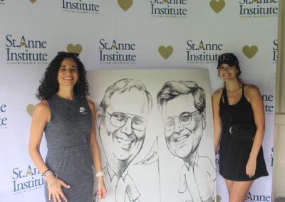 Two women standing next to a caricature of two men.