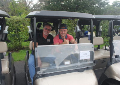 Two men sitting in golf carts.