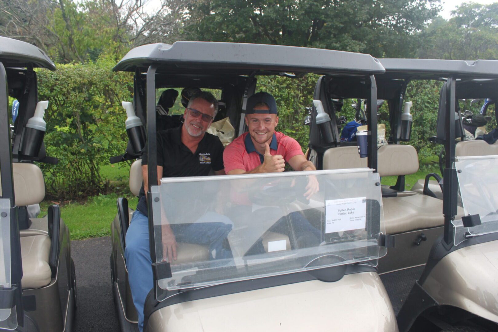 Two men sitting in golf carts.