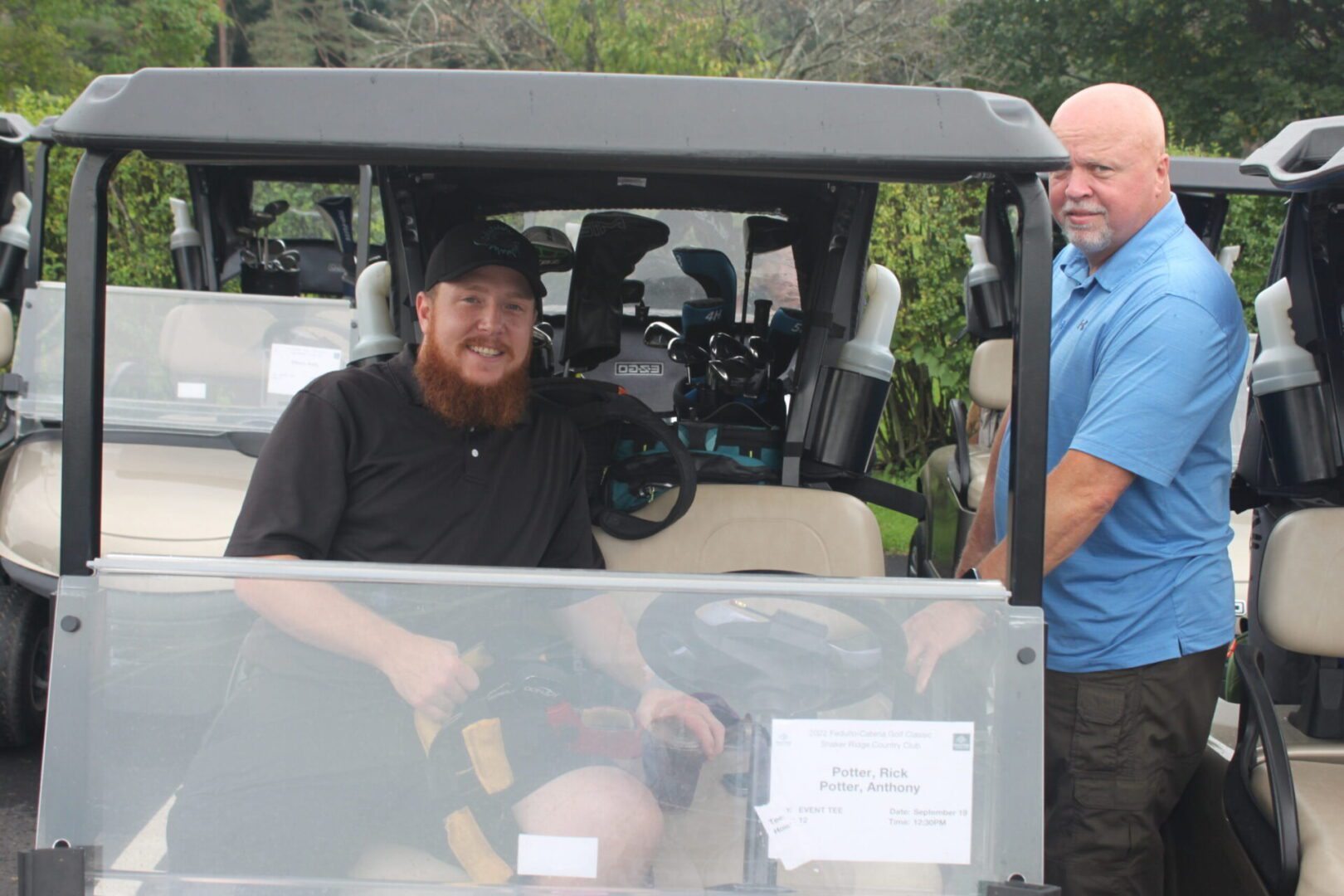Two men in a golf cart.