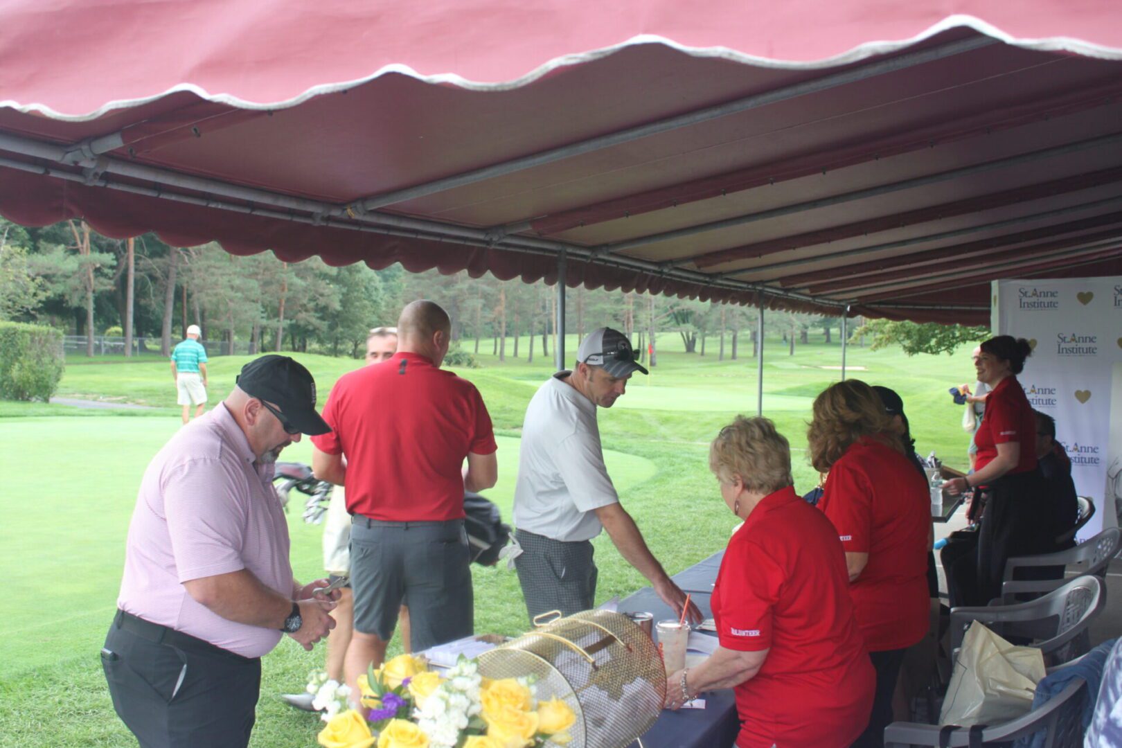 A group of people standing under a tent.