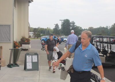 A man carrying a golf bag.