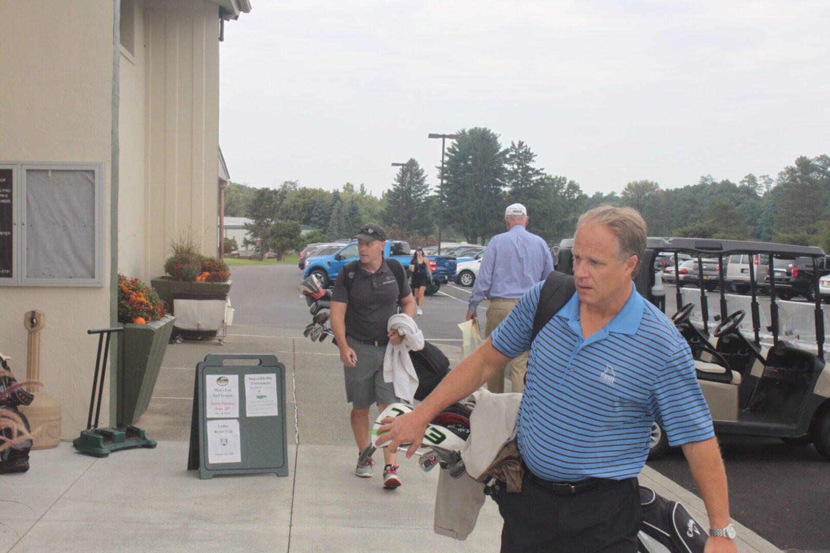 A man carrying a golf bag.