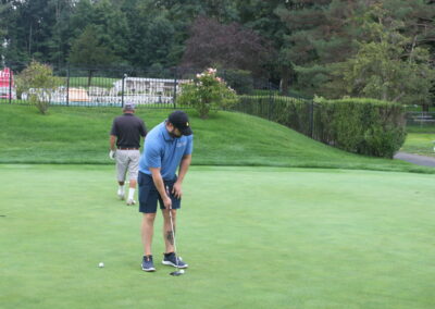 A group of people playing golf on a green.