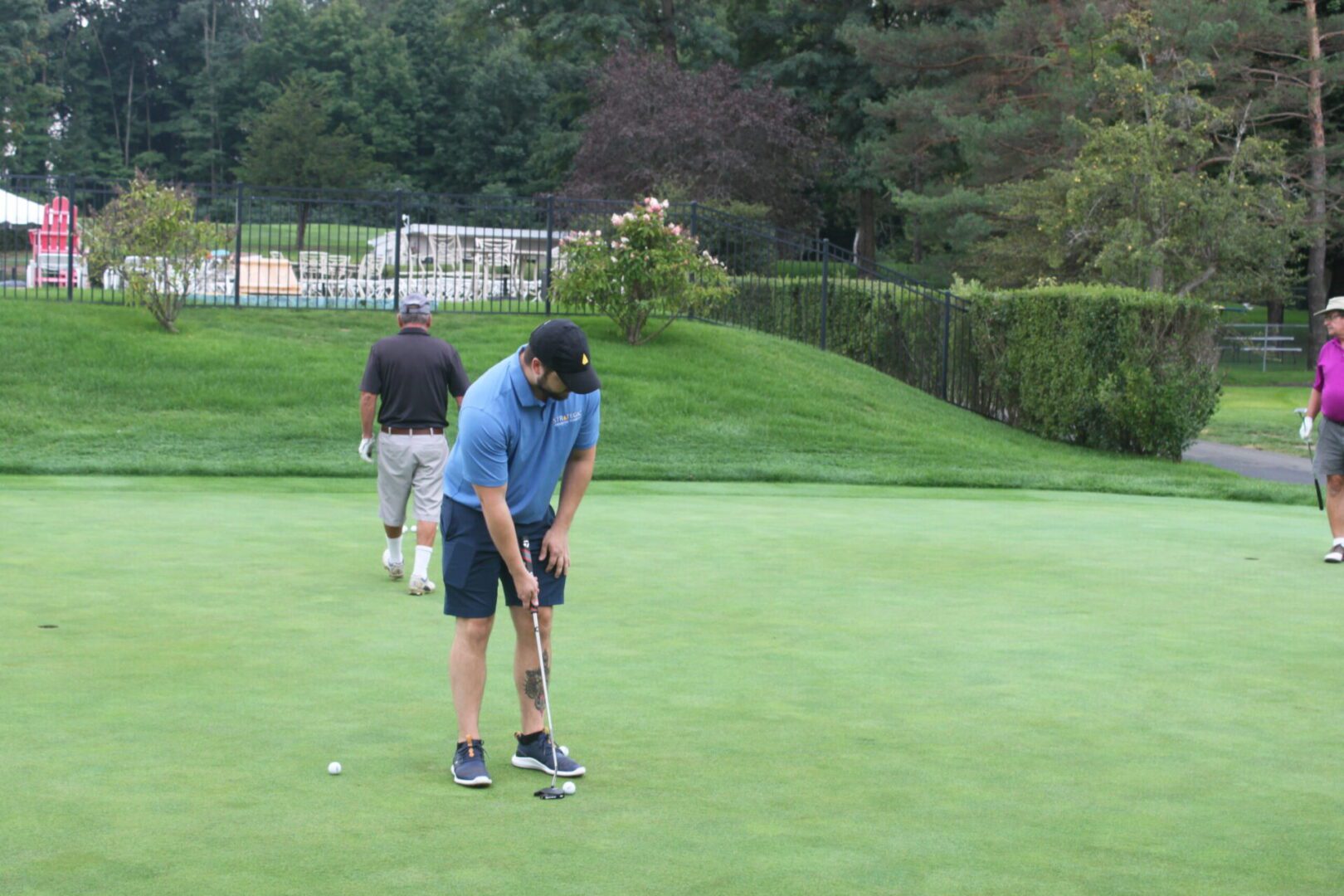 A group of people playing golf on a green.