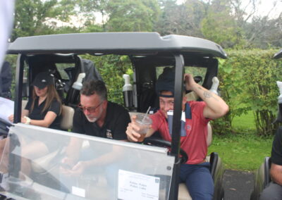 A group of people sitting in a golf cart.