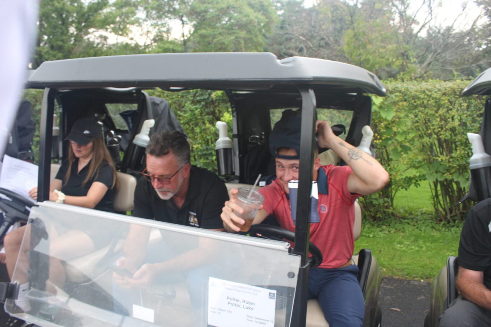 A group of people sitting in a golf cart.