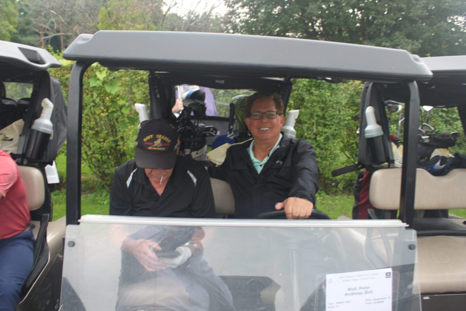 A group of people sitting in a golf cart.