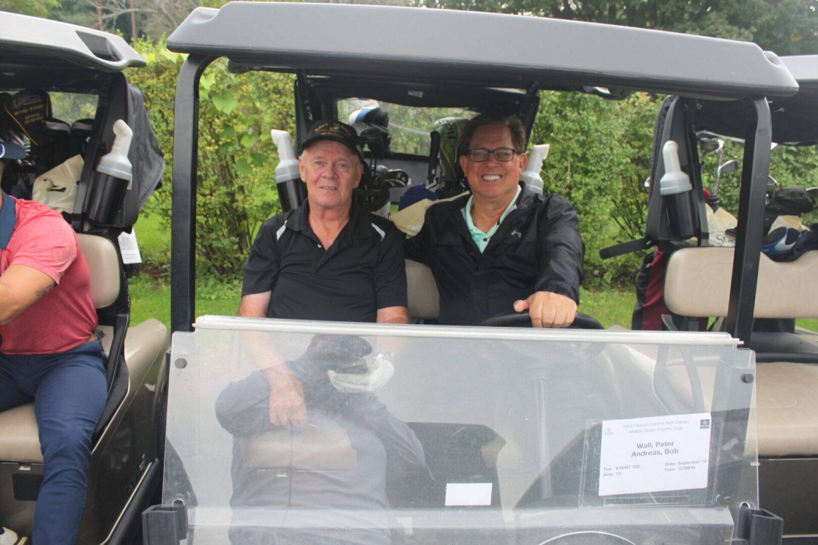 A group of men in golf carts smiling at the camera.