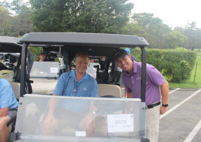 A group of men in a golf cart.