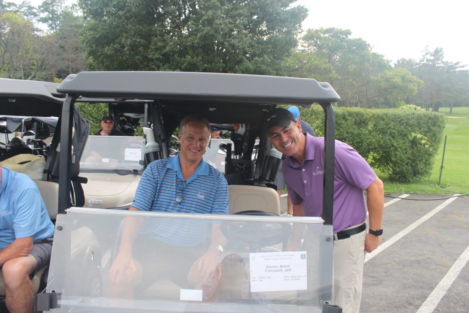 A group of men in a golf cart.