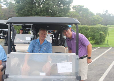 A group of men in a golf cart.