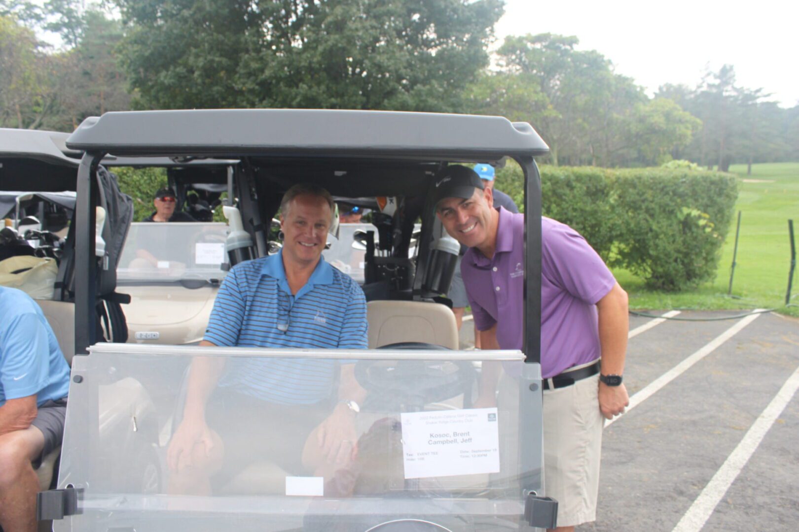 A group of men in a golf cart.