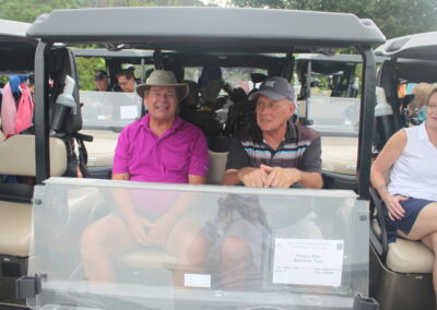 A group of people sitting in a golf cart.