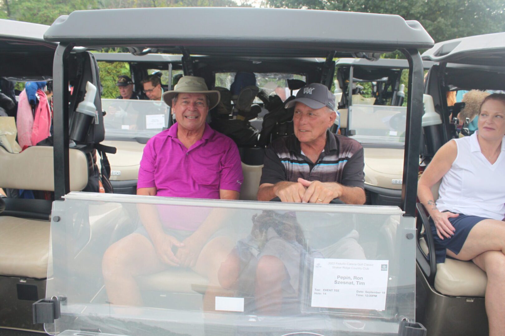 A group of people sitting in a golf cart.