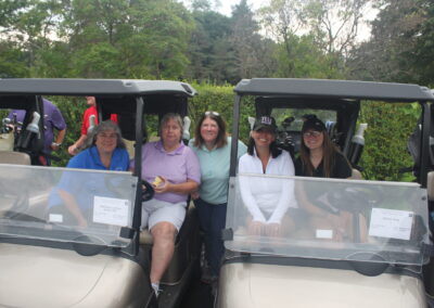 A group of people posing for a picture in a golf cart.